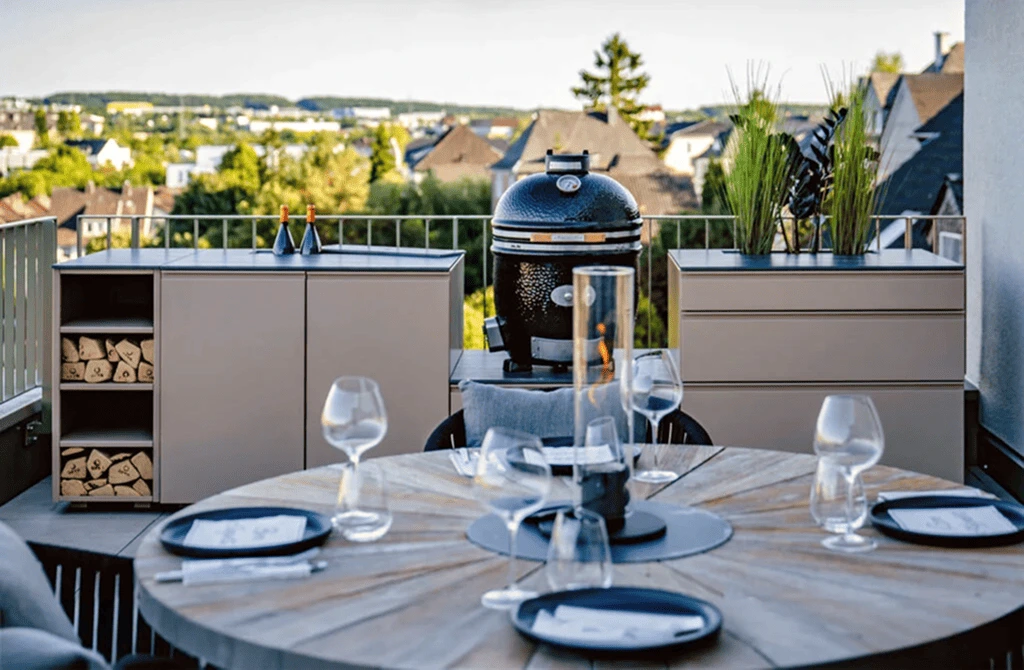 Autdoorküche vor einem gedeckten Tisch